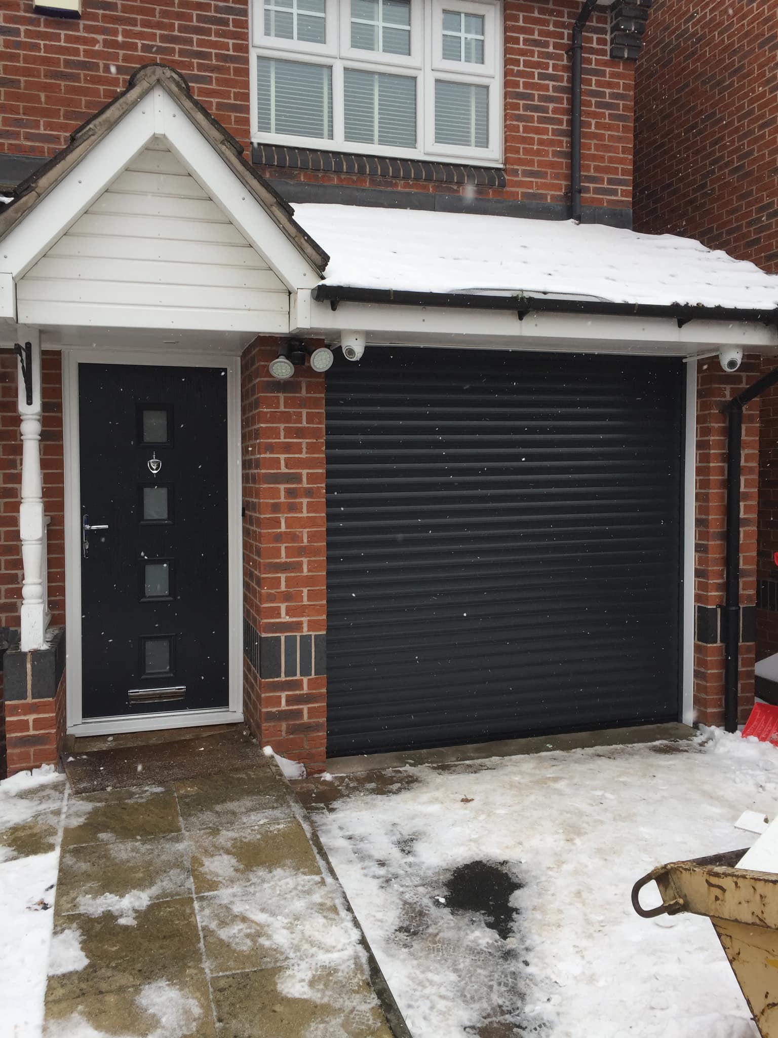 black matching composite front door and roller shutter black garage door